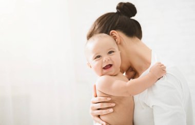 Annenin ellerinde tatlı bebek, kameraya gülümsüyor, kopyalama alanı