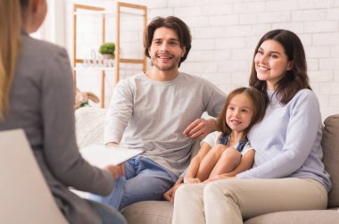 Başarılı bir aile terapisinden sonra Küçük Kızlı Mutlu Ebeveynler Psikologlar Ofisi 'nde birlikte oturuyorlar.