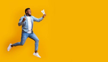 Benim paramı al. Afro adam, aktif alıcı, elinde dolarla zıplıyor ve koşuyor, büyük satışlar için heyecanlı, sarı arka plan ve boş alan..