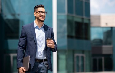 Bilgisayarlı ve kahveli neşeli orta doğulu genç işadamı caddeden modern ofis binasına doğru yürüyor, sabah işe gidiyor, fotokopi alanı olan bir panorama.