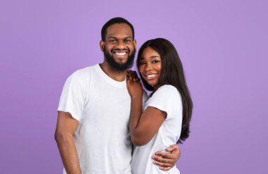 Sevgi ve ilgi. Çekici Afrikalı Amerikalı kadın ve erkeğin portresi sarılıyor, birlikte vakit geçiriyor, mavi stüdyo arka planında izole edilmiş duruyor, poz veriyor ve kameraya bakıyor. Uzayı kopyala, afiş