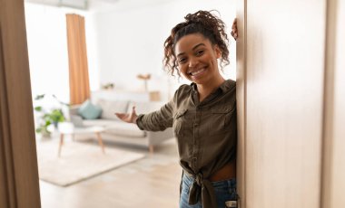 Evime hoş geldiniz. Milenyum güzeli siyahi kadın kapıyı açıyor ve içeri girmeye davet ediyor, kameraya gülümsüyor. Gayrimenkul sahibi. Misafirperverlik Konsepti