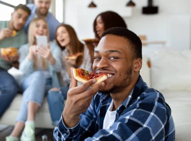 Çekici siyahi adam lezzetli pizzalar yiyor, çeşitli arkadaşları cep telefonlarıyla arka planda eğleniyor. Milenyum öğrencileri sosyal toplanıyorlar, konuşuyorlar ve evde gülüyorlar. İnsanlar ve yaşam tarzları