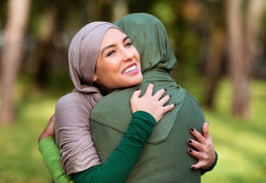 İki Çok Irklı İslamcı Kadın Yeşil Park 'ta Dışarda Poz Veriyor. Mutlu İslami kadınlar sevgilerini ve desteklerini ifade ediyorlar. Birlik ve Dostluk Konsepti