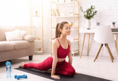 İspanyol kız evde dizüstü bilgisayarında esneme kurslarını izlerken egzersiz yapıyor.