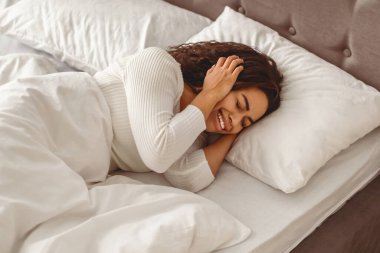 Endişe ve Depresyon Konsepti. Stresli genç Afrikalı Amerikalı kadın portresi ağlıyor, başını tutuyor, kulaklarını örtüyor, battaniyenin altında yatıyordu. Yalnız hisseden siyah bir kadın