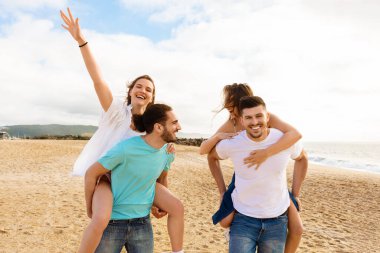 Dört arkadaşından oluşan bir grup sahilde harika vakit geçiriyor. Güneşli bir öğleden sonrayı birlikte dalgalar eşliğinde kutlarken ikisi diğerlerinin sırtında neşeyle geziyorlar..