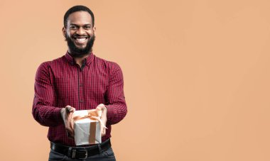 Kutlarım. Neşeli Siyah Adam Sarı Stüdyo Duvarının Üzerindeki Kamera Pozisyonuna Hediye Kutusu Veriyor
