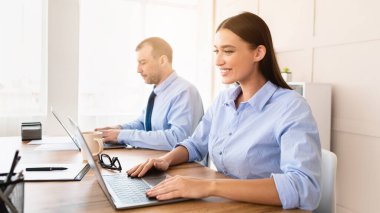 Modern ofiste oturan dizüstü bilgisayarlar üzerinde çalışan iş kadını ve erkek. Kurumsal Yaşam Tarzı Konsepti