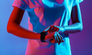Cihazı olan bin yıllar. Smartwatch kadın eli, kırpılmış, neon, stüdyo çekimi