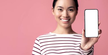 Çevrimiçi teklif. Gülen Asyalı kadının ellerinde boş beyaz ekranlı akıllı telefon, Uygulama tasarımı ve reklamı için kopyalama alanı olan mutlu Koreli genç bayan,