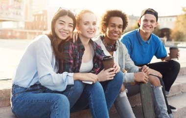 Bir grup genç paten parkında takılıp, aktif sporlarda kahve molası, boş alan