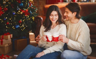 Güzel çift xmas kakao, evde, Noel ağacının yanında kucaklayan zevk alan kopyalama