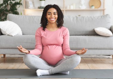 Mutlu siyahlar evde meditasyon yapan bir bayanın oturma odasında yerde oturmasını bekliyor.