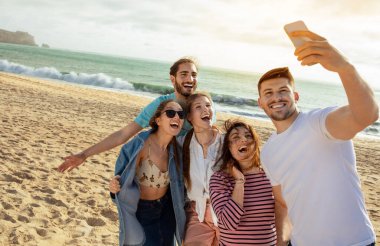 Bin yıllık Avrupalı ve Arap dostlarımız iyi eğlenceler, akıllı telefondan selfie çekiyorlar, okyanus sahilinde boş vakitlerin tadını çıkarıyorlar. Günlük ve sosyal ağ, açık hava partisi, tatil ve gezi uygulaması