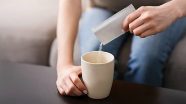 Bulaşıcı hastalık tedavisi. Tanınmayan bir kadın paketten bardağa ilaç dolduruyor. Kapalı alanda, yakından bakıyor.
