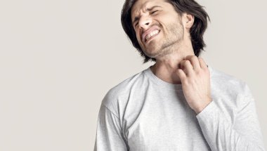 Alerji isiliği, deri iltihabı. Derisi kaşınan ve boğazı kaşınan bir adam.