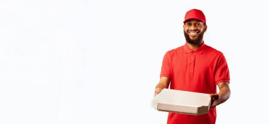 Afrikalı kurye, sarı arka plandaki stüdyoda pizza kutusu teslim ediyor. Pizzacı Teslimat Servisi.