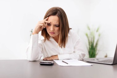 A businesswoman appears frustrated while looking at her phone in an office environment. Her focused expression suggests she is dealing with a work-related issue during a busy day. clipart