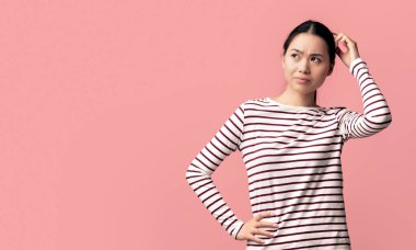 Zor bir seçim. Kafası Karışık Asyalı Kadın Dokunma Kafası ve Kopya Boşluğuna Bakarken Pembe Arkaplan, Panorama 'da tek başına dururken Teklif Düşünen Kafası Karışık Genç Koreli Kadın