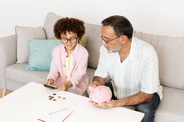 Bir büyükbaba ve torunu evde kalpten bir anın tadını çıkarırlar, çocuk telefona bakarken birlikte bozuk paraları sayarlar. Bu faaliyet aşkı, ilgiyi ve değerli hayat derslerini teşvik eder..