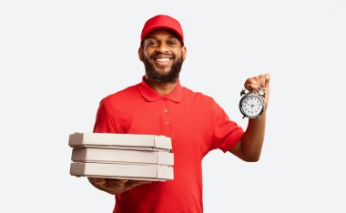 Pizzeria Courier Pizza Tutma Kutuları ve Saati Sarı Stüdyo Arkaplanındaki Kamera Pozisyonuna Gülümsüyor.