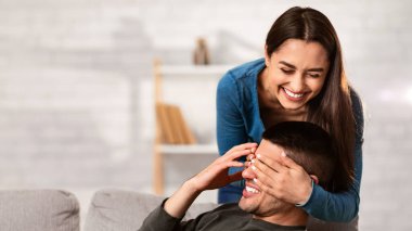 Romantik sürpriz. Sevgili kız arkadaş, erkek arkadaşının gözlerini arkadan kapatıyor, apartmanlarında eğleniyor, mekanı kopyalıyor.