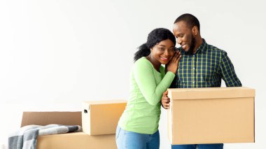 Mutlu Afrika kökenli Amerikalı Çiftin Yeni Daire 'ye taşınışının portresi, neşeli siyah eşler ellerinde karton kutular, mülkiyet ve taşınma kutlamaları, kopyalama alanı.