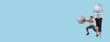 İki birey denge toplarını kullanarak bir fitness seansına katılıyor. Bir kişi topu tutarken hamlesini yapıyor, diğeri de başınızın üzerinden bir top kaldırıyor, güç ve denge gösteriyor..