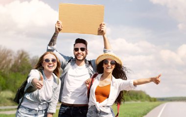 Sırt çantalı, otostop çeken, otostop çeken, bedava yolculuk yapan yaz macerası yaşayan, kopya alanı olan neşeli arkadaşlar. Otomatik yolculuk, yaz özgürlüğü, seyahat ve arkadaşlık kavramı