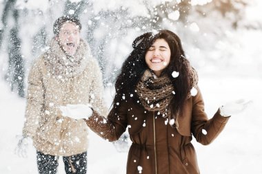 Noel havası. Kar atan çift, sabahları ormanda eğlenceli bir yürüyüş yapıyor..