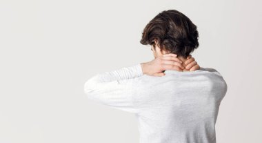 Kas ağrısı ve sağlığın korunması. Adam kendi kendine masaj yapıyor. Boynuna, sırtına, stüdyo çekimine.