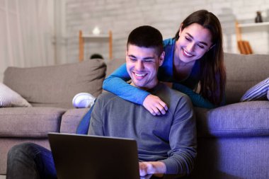 Ev Kavramında Rahatlamak. Tatlı çocuk ve kız bilgisayar kullanarak evlerinde vakit geçiriyorlar.