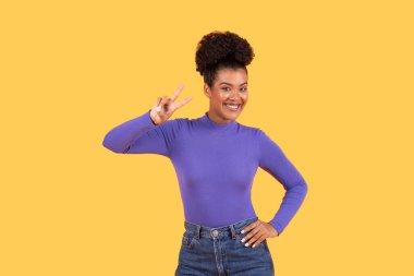 Genç bir İspanyol kadın neşeli bir barış işaretiyle enerjik kişiliğini sergiliyor..