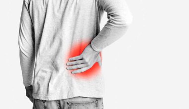 Acısını zapt eden genç bir adam, kırmızılı tek renkli bir fotoğraf, iltihaplanma sembolü olarak, panorama