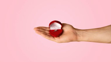 Turuncu arka planda nişan yüzüğü olan tanınmamış bir adam, yakın plan. Panorama