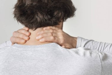 Boyun ağrısı konsepti. Erkekler hafif arka planda izole edilmiş hassas noktaları ovalarlar.