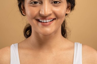 Genç bir Doğu Hindistanlı kadın cilt bakımı rutinini uyguluyor, neşe ve güzellik saçıyor. Kendini sakin, izole bir ortamda şımartıyor, doğal bir güven sergiliyor..