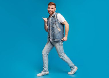 Mavi arka plan, stüdyo, kopya alanı üzerinde jestleri kadar başparmak ile cool bin yıllık adam dans