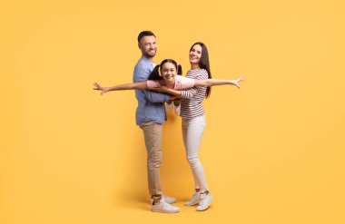Bir anne ve baba, birbirlerine sevgi dolu ve neşeli bir şekilde sarılıp güçlü aile bağlarını vurguladıkları ergen kızlarıyla neşeli bir etkileşimi paylaşıyorlar..