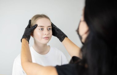 İki kadın bir kuaförde şımartıcı bir güzellik prosedürü uyguluyor. Bir kadın kalıcı makyaj uygulamaya odaklanmış, uzun süreli görünümü garantiye alıyor..