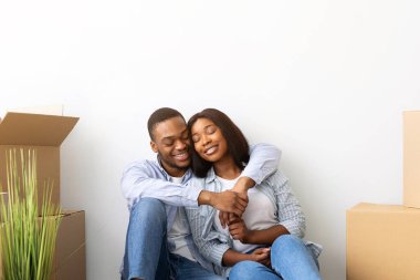 Siyahi eşleri sevmek, malzeme kutuları arasında kucaklaşmak, içinde eşyaların olduğu boş daireler, fotokopi alanı. Mutlu Afrikalı Amerikalı erkek ve bayan taşınıyor.