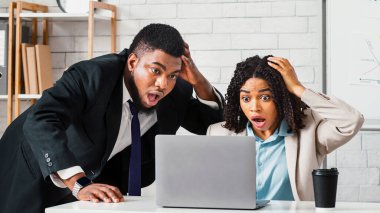 Dehşete düşmüş iş arkadaşları bilgisayar ekranına bakıyor, iş projesinde hata buluyor. Panorama