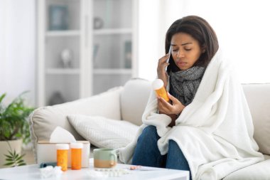 Genç siyah bir kadın kanepeye oturur, battaniyeye sarınır, elinde bir ilaç şişesi vardır. Oturma odasında telefonda konuşurken endişeli görünüyor. Uzayın fotokopisini çek.