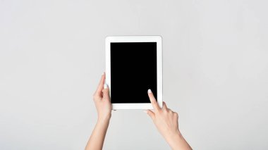 Beyaz arkaplandaki tablet bilgisayarın boş ekranına bir kadın eli dokunuyor. Tasarımınız için bir model. Panorama