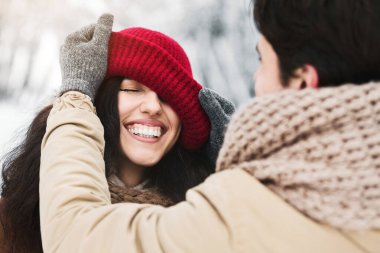 Kış buluşması. Sevgili Sevgilisinin Karlı Orman 'da Dışarıda Duran Kız Arkadaşına Şapkasını Takması
