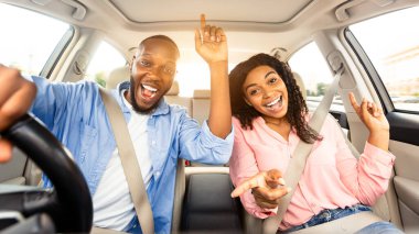 - Tatile çıkıyoruz. - Evet. Arabalarını süren, müzik eşliğinde dans eden ve en sevdiği şarkıyı söyleyen iki kişinin ön manzara portresi.