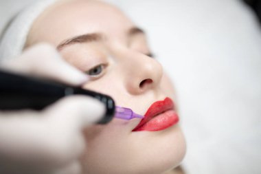 Kadınlar bir güzellik salonunda uzun süreli profesyonel makyaj seanslarının keyfini çıkarırlar. Prosedür onların özelliklerini artırarak, rahatlama ve güven açısından şımartıcı bir deneyim sağlıyor..