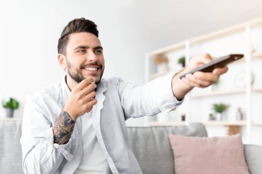 Neşeli milenyum çocuğu televizyon izliyor, patlamış mısır yiyor, oturma odasındaki koltukta dinlenirken uzaktan kumandayla kanal değiştiriyor, kopya çekiyor. Boş zaman kavramı