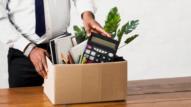 Tanımlanamayan siyah adam ofis eşyalarını karton kutuda topluyor. Afrikalı Amerikalı bir adamın işini kaybetmesi, işyerinden eşyalarıyla ayrılması. Ekonomik kriz ve işsizlik